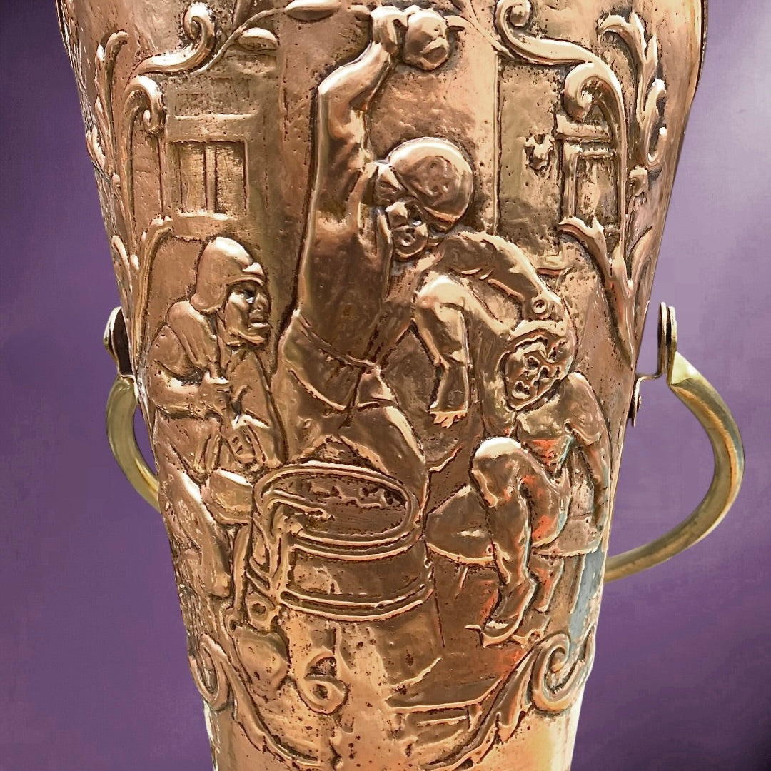 Ancien porte-parapluie en cuivre repoussé – scène flamande en relief – anse en laiton