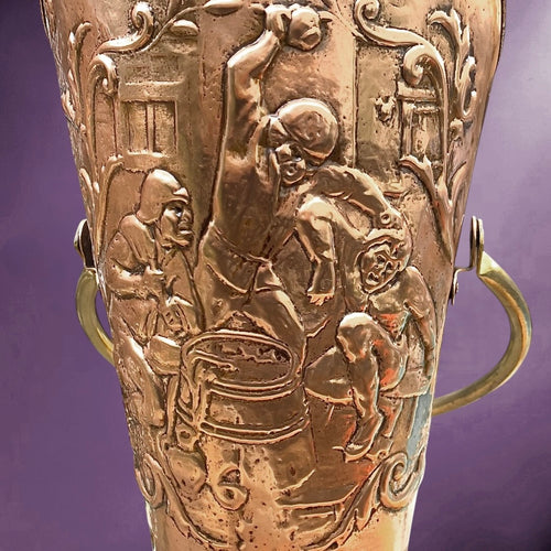 Ancien porte-parapluie en cuivre repoussé – scène flamande en relief – anse en laiton